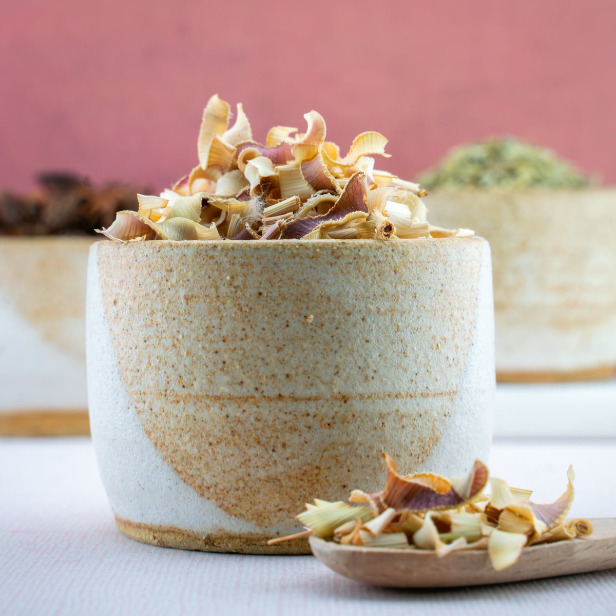Dried lemongrass pieces in ceramic bowl with loose herbs